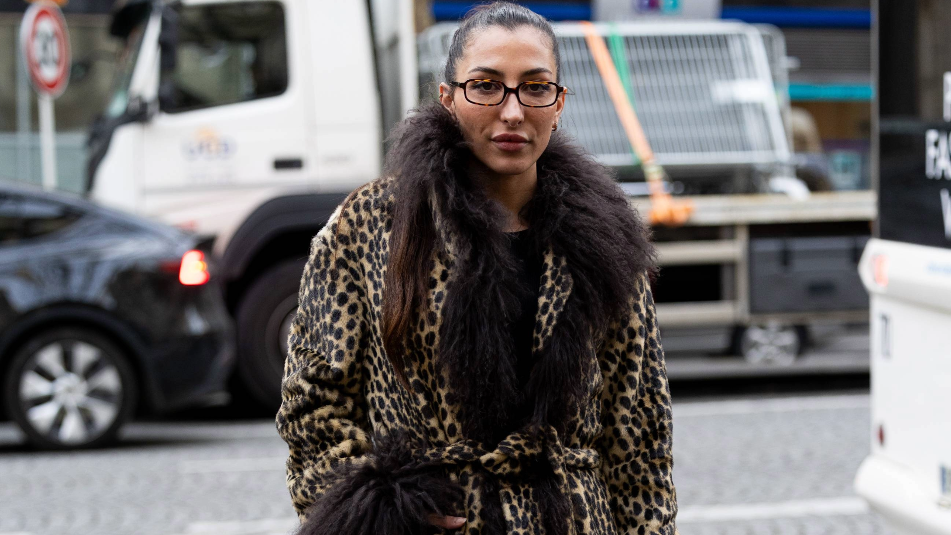 PARIS, FRANCE - MARCH 10: A guest wears brown glasses, a leopard printed coat with brown fur applications, a black sweater and black leather knee high boots outside Rokh during the Womenswear Fall/Winter 2025/2026 as part of Paris Fashion Week on March 10, 2025 in Paris, France. (Photo by Valentina Frugiuele/Getty Images)