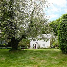 house exterior with garden area and white wall