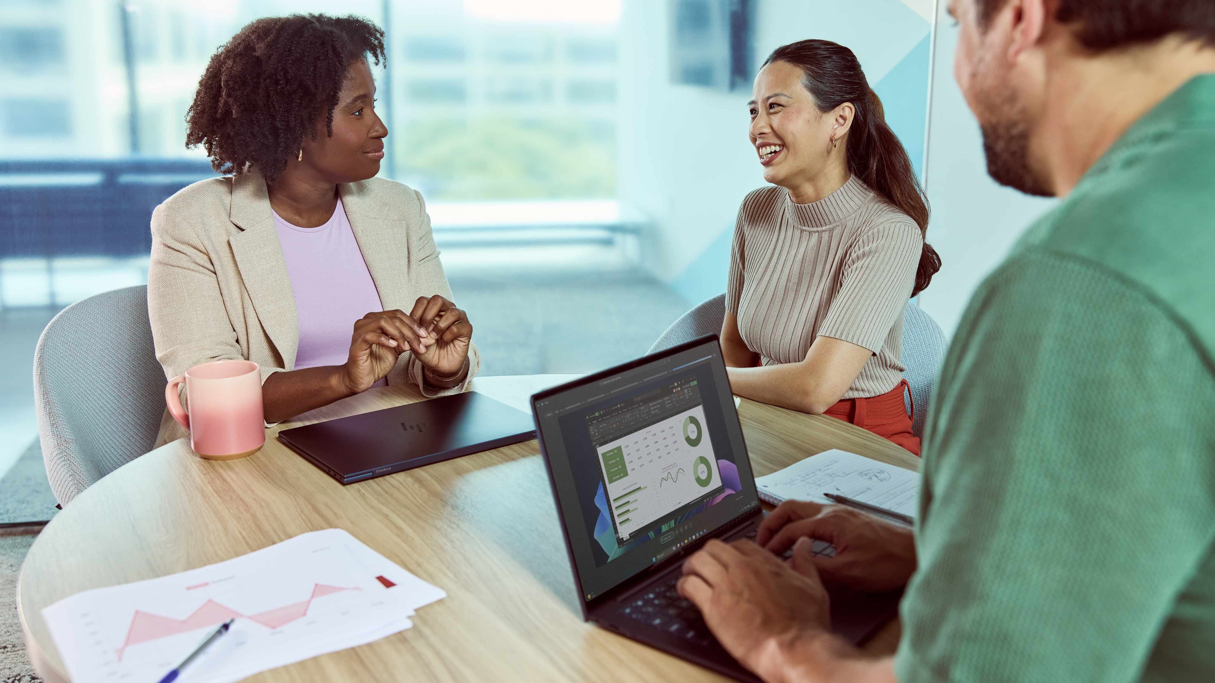 Three people sitting together at a table, with one using the HP EliteBook Ultra 14 (G1i) and another with the HP EliteBook Ultra 14 (G1i) closed in front of them.