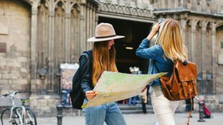 woman looking at paper map in city centre