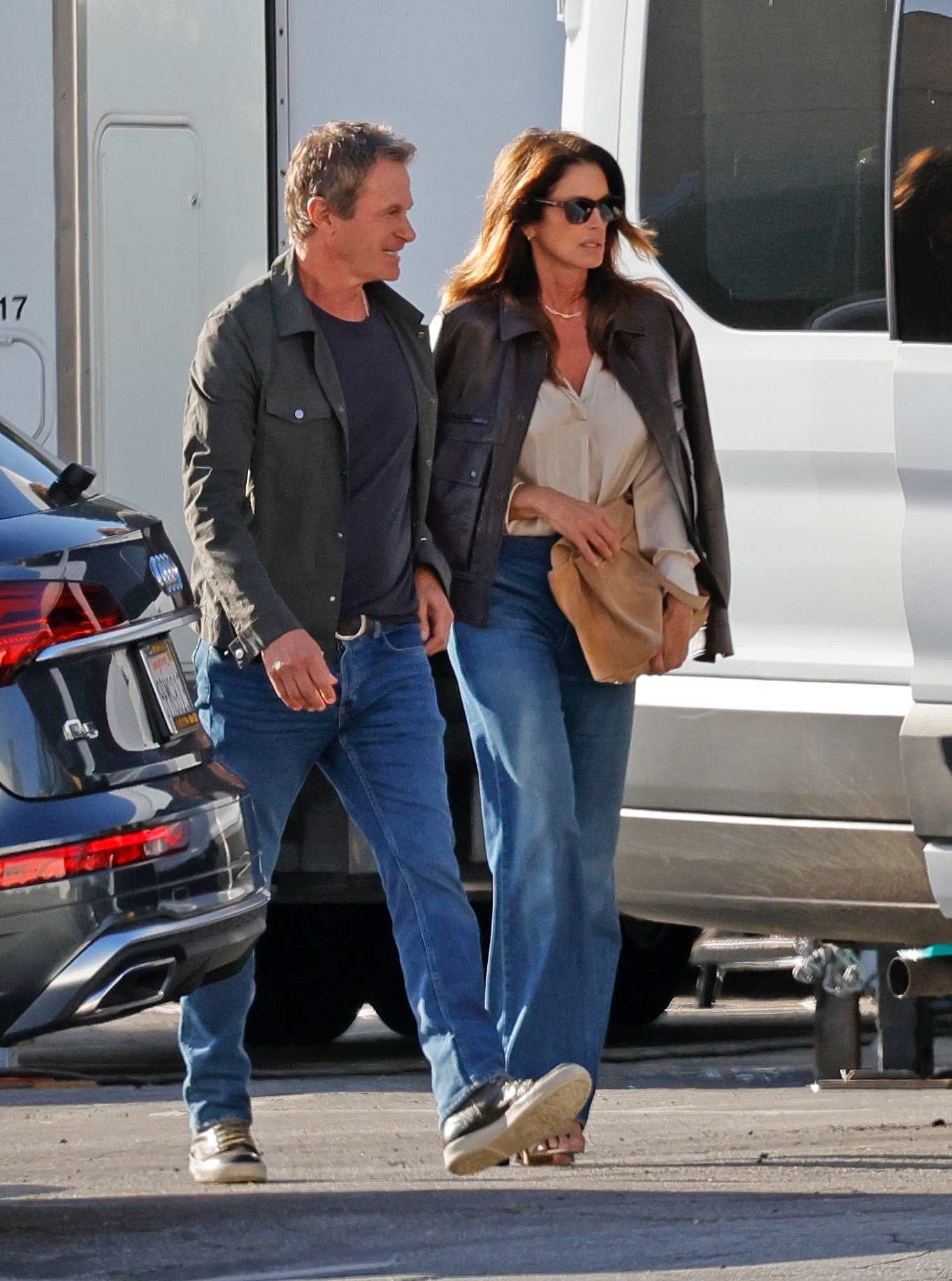 An image of Cindy Crawford wearing bootcut jeans, satin shirt and leather jacket whilst out in Los Angeles.