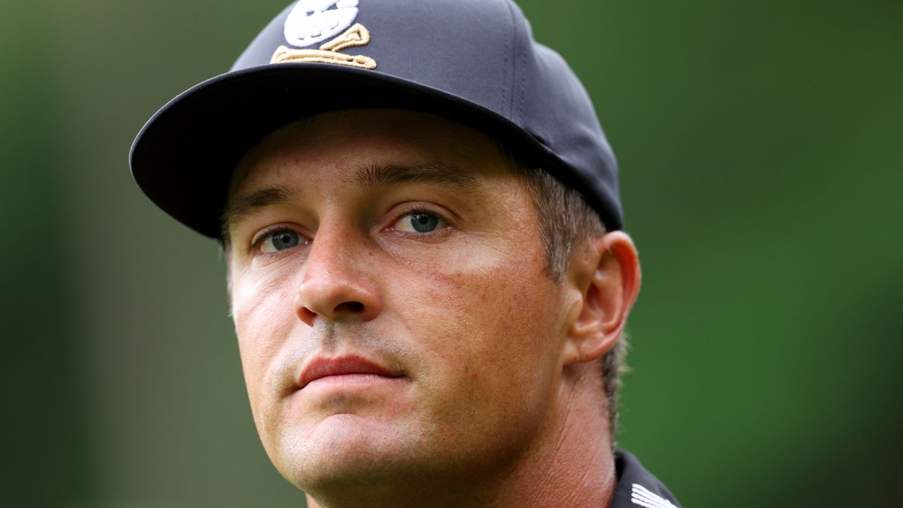 A Bryson DeChambeau headshot of him wearing a black cap