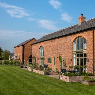 brick house with grassland and garden