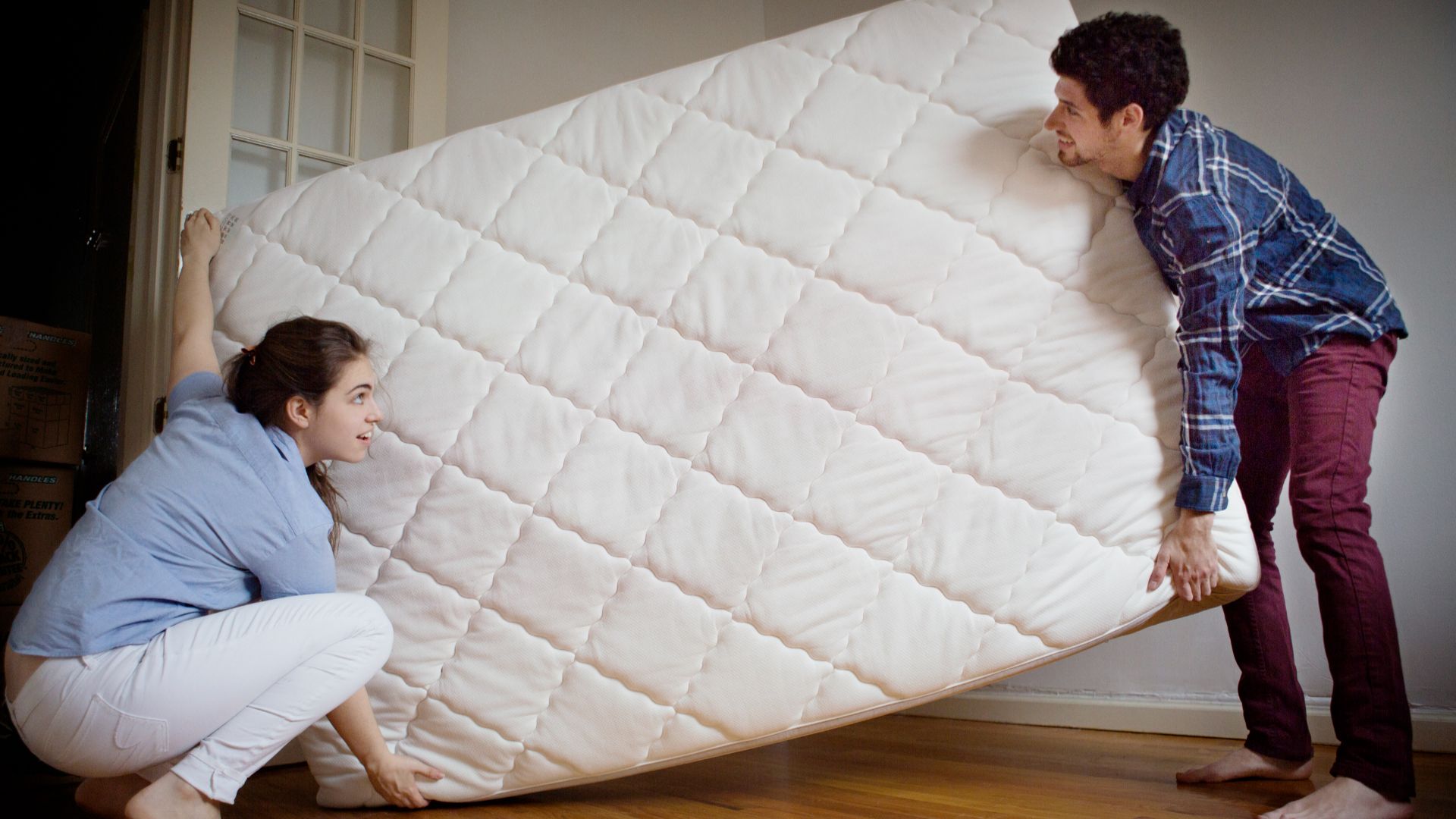 A man and a women carrying a mattress
