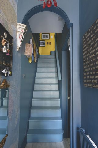 blue painted stairway walls with yellow landing