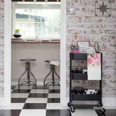 Black trolley displaying kitchen utensils next to doorframe