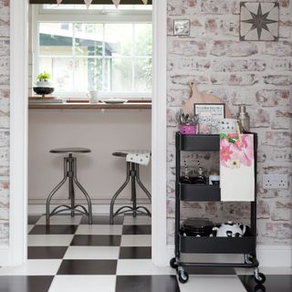 Black trolley displaying kitchen utensils next to doorframe