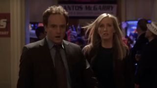 Bradley Whitford as Josh Lyman and Janel Monoley as Donna Moss walking and talking on The West Wing