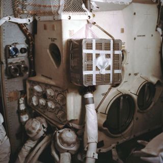 A square lithium hydroxide (LiOH) canister, modified to fit a circular opening, is seen aboard the Apollo 13 spacecraft in 1970.
