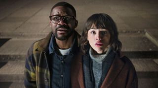 A man and a woman look up to the sky in confusion