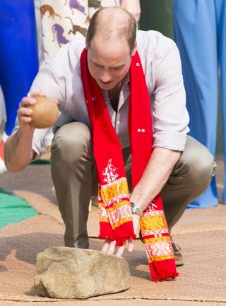 Prince William cracking a coconut