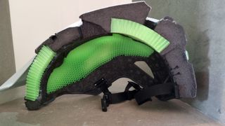 A cross-section of an Endura MT500 MIPS helmet, showing the bright green Koroyd layer