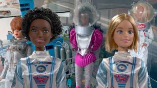 three barbie dolls in space suits