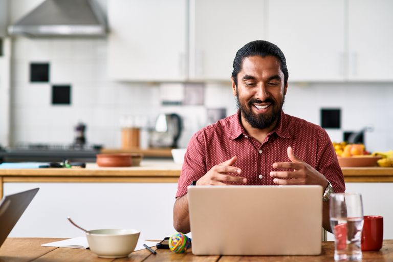 man using laptop in kitchen