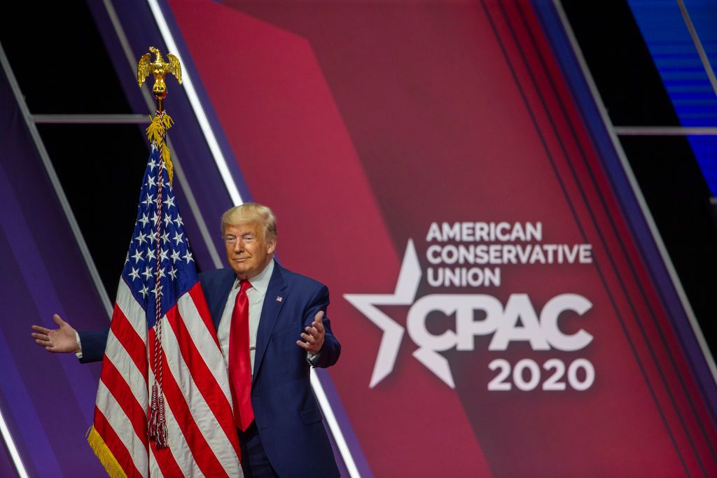 Donald Trump prepares to hug a flag at CPAC.