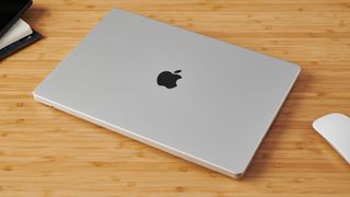 Closed MacBook Pro 16-inch on wooden table in modern office