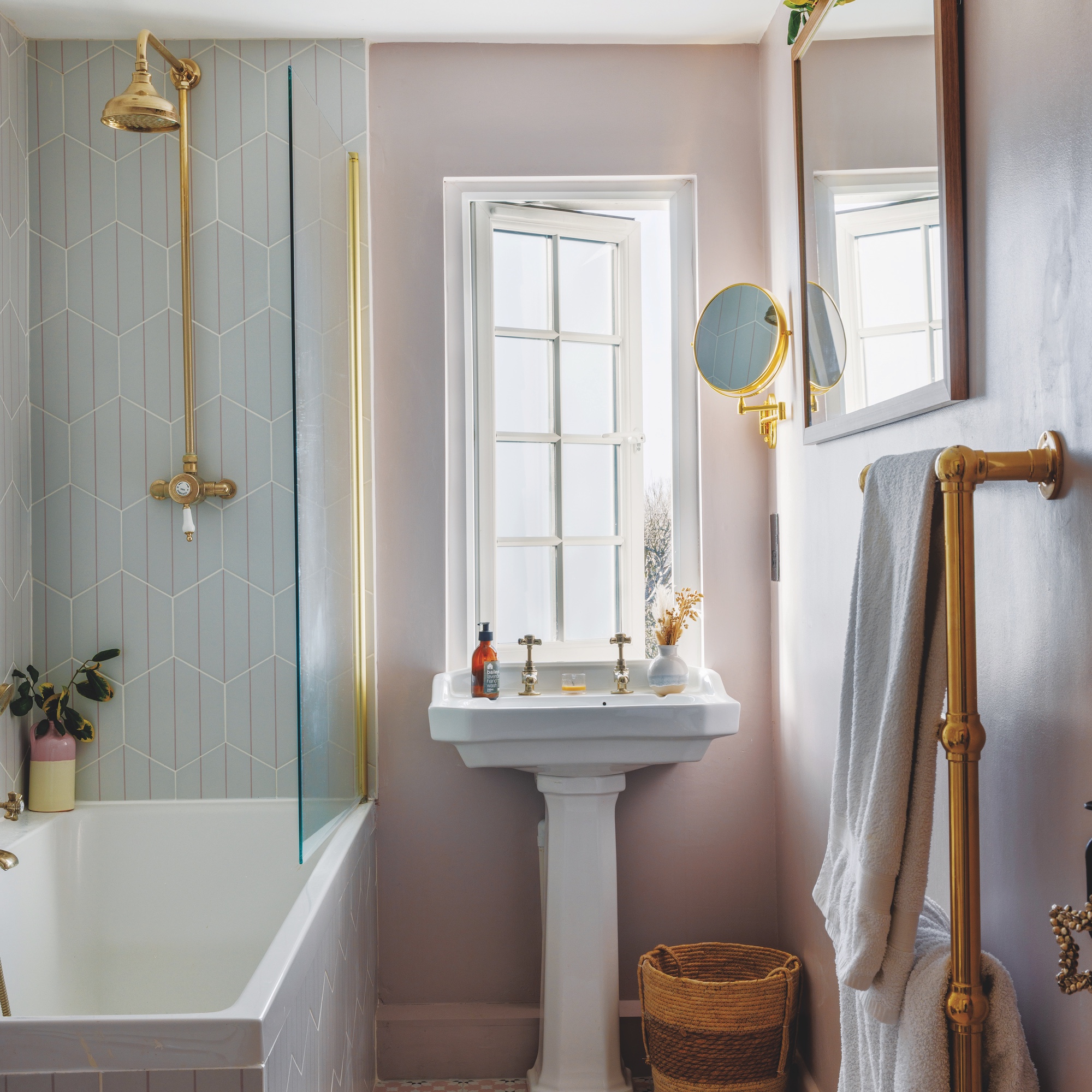 bathroom with pedestal basin and white bath with brass taps and shower
