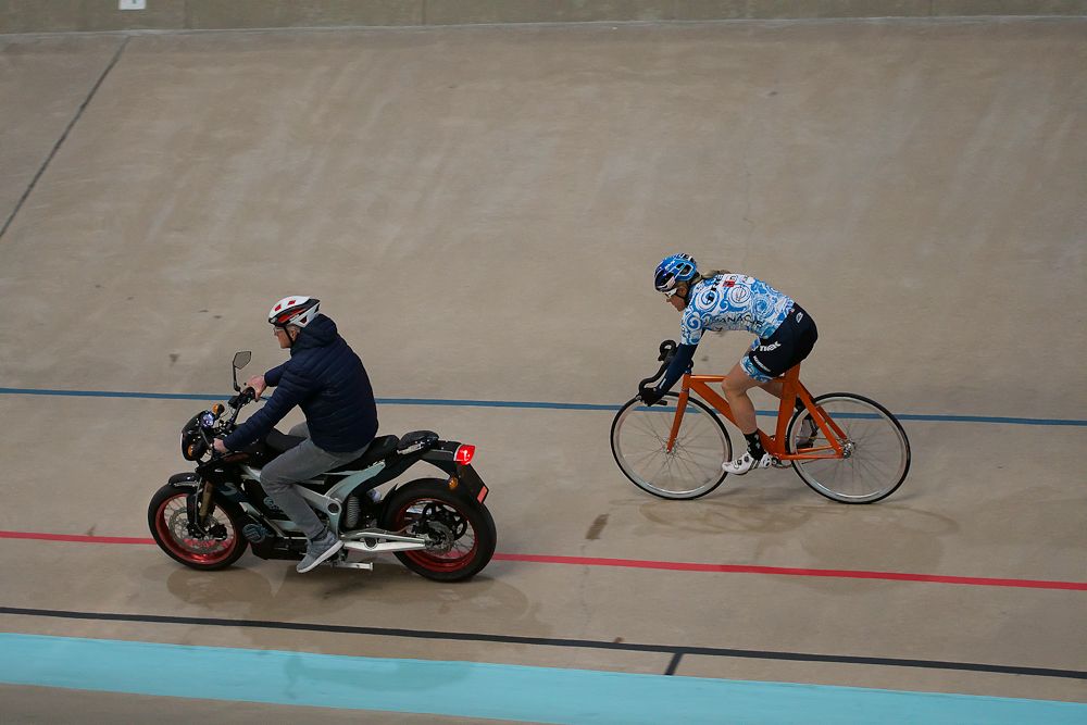 Katie Compton rides behind a moto at USA Cycling's recent track talent ID camp