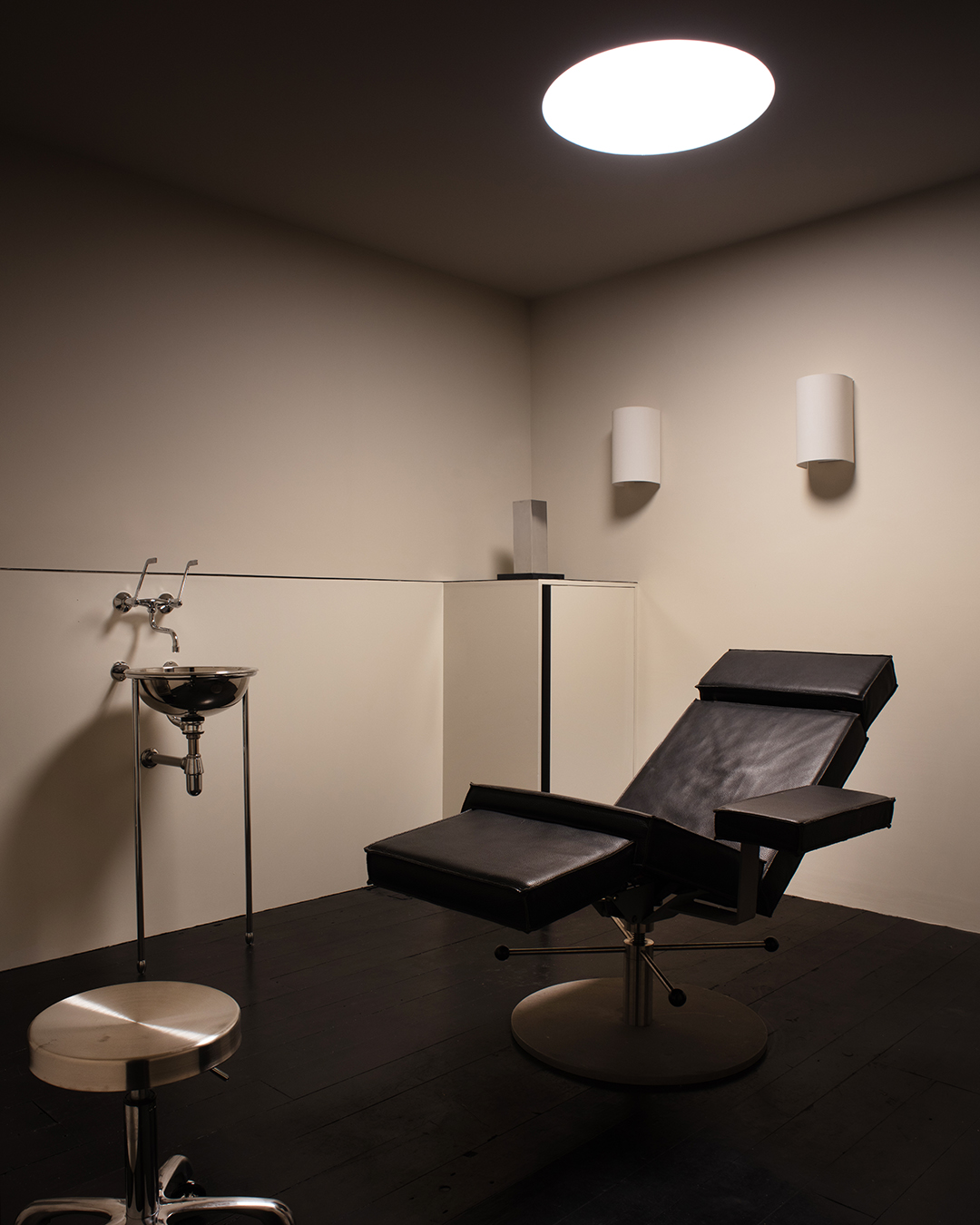 Inside Dr Karen Doherty Shoreditch clinic with black leather treatment chairs and white walls