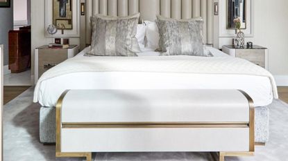 Bedroom with wooden flooring, double bed on a grey rug with white and grey bedding.