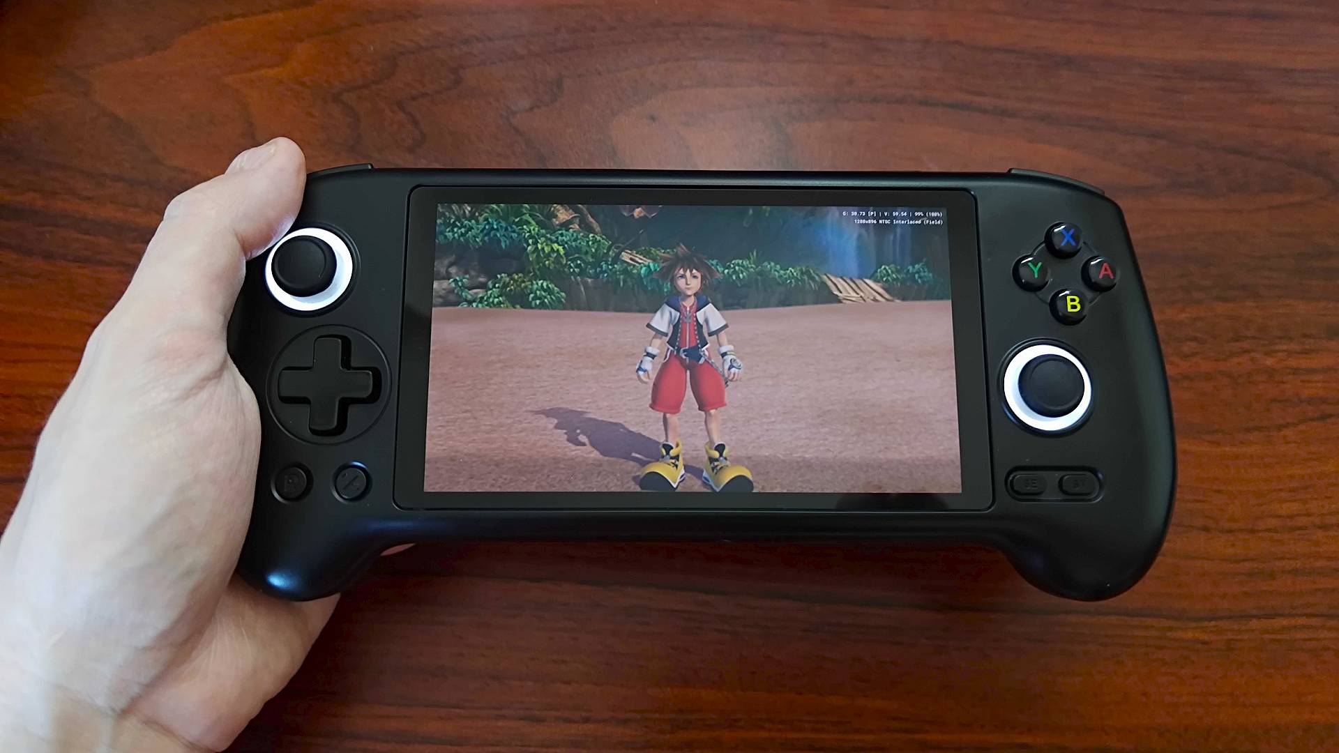 Hand holding Anbernic RG556 handheld with Kingdom Hearts cutscene on screen.
