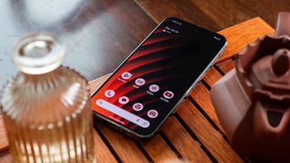 A Google Pixel 9 Pro XL with an orange and red striped wallpaper on a tea tray