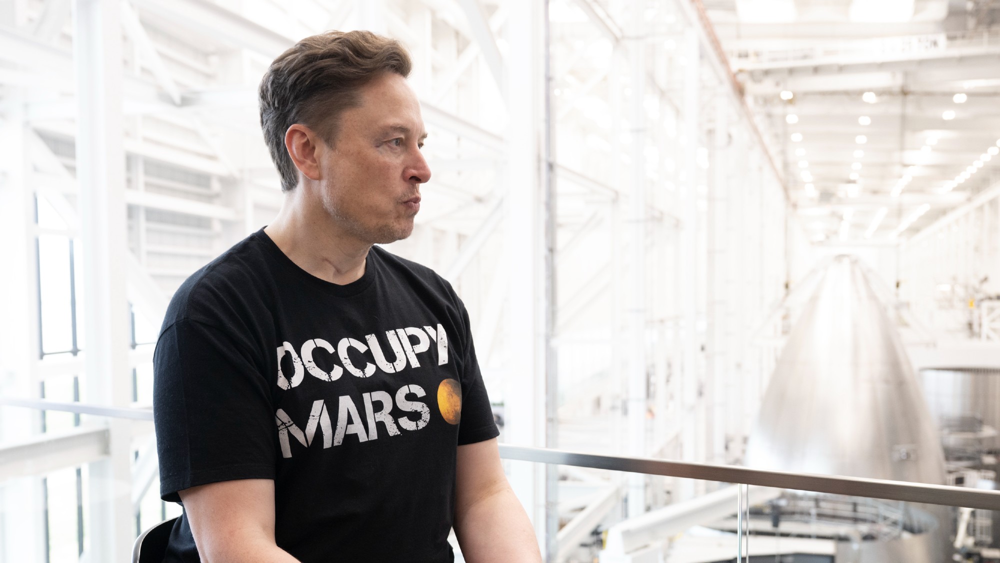 Elon Musk in an Occupy Mars t-shirt inside a Space X facility in Brownsville, Texas