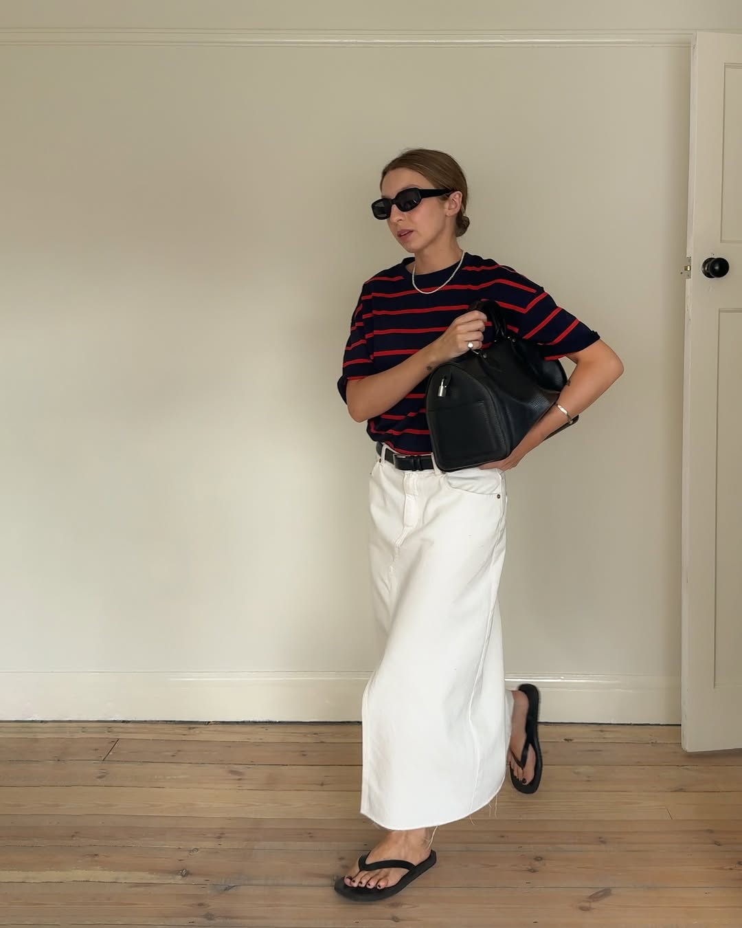 @brittanybathgate wearing a long denim skirt, striped t-shirt and flipp-flops
