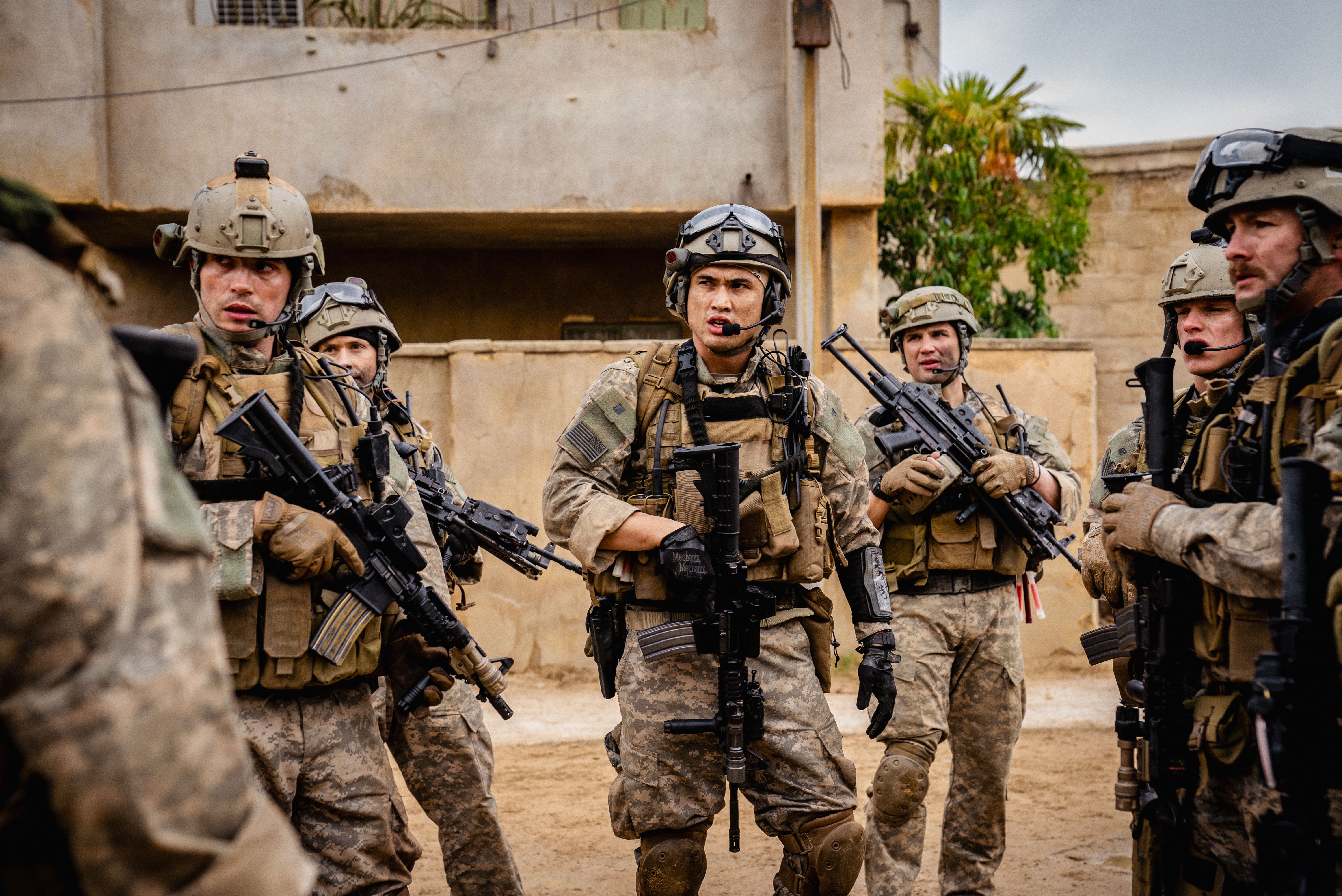 A group of soldiers standing in full gear with weapons.