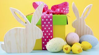 Wooden Easter bunnies next to a colorful gift box