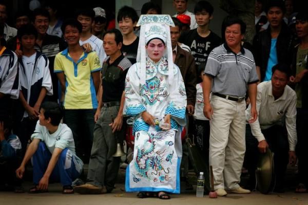 A man dressed in traditional theatrical costume in the town of Lingao.