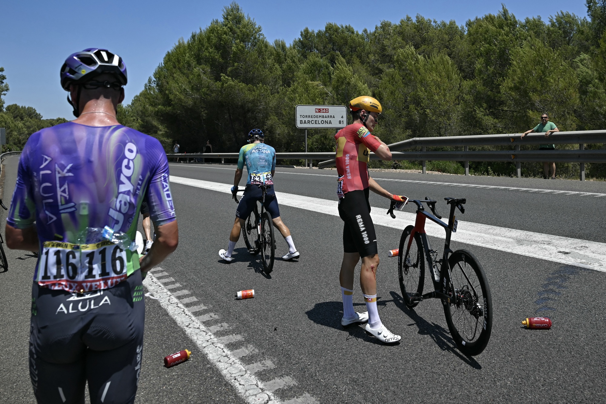 Three riders standing in the road after the crash