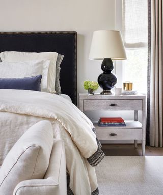 neutral bedroom with blue bed, cream duvet and cream chaise