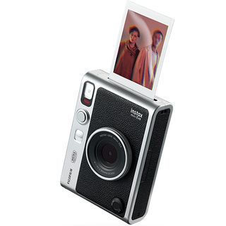 Instax Mini Evo against a white background ejecting a photograph of two young people