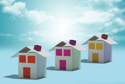 three paper houses with colorful doors and windows against blue sky