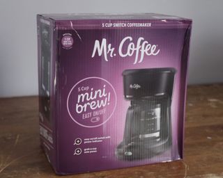 Mr. Coffee 5-Cup Mini Brew Coffee Maker in purple cardboard packaging