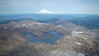 A close-up photo of spirit lake with another mountain in the background