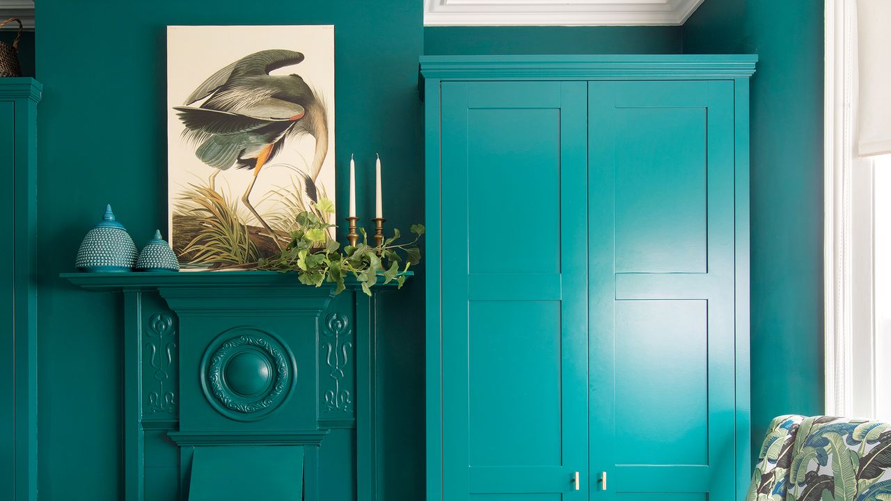 Bedroom with walls, fireplace and wardrobes all painted turquoise