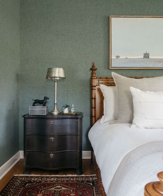 Greeen bedroom with wooden bed and white sheets