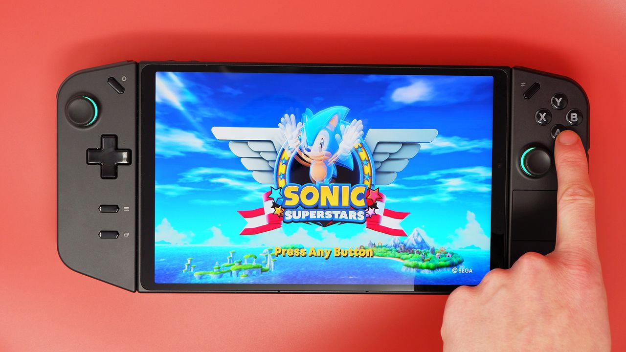 The Lenovo Legion Go on a red background and playing Sonic.