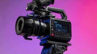 Blackmagic Pyxis 6K camera in the studio, mounted to video tripod, with a vibrant magenta background