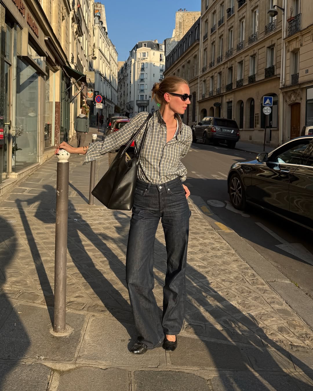 Amalie Moosgaard wearing a plaid shirt, indigo jeans, and ballet flats