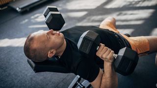 Man performing incline chest press with dumbbells