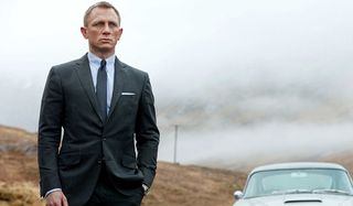 Skyfall Daniel Craig in a suit as James Bond next to car