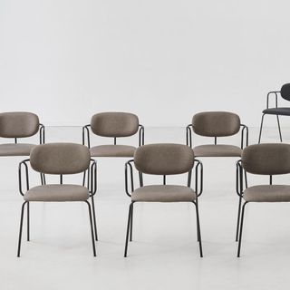 Six simple chairs with padded seats and backs, and plain metal arms