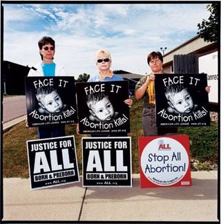 three women holding anti-abortion signs