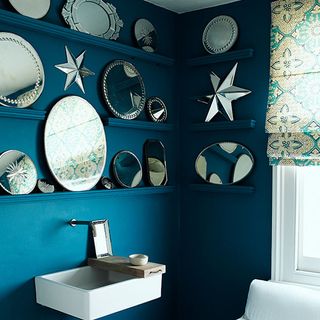 blue wall with shelves and multiple mirrors