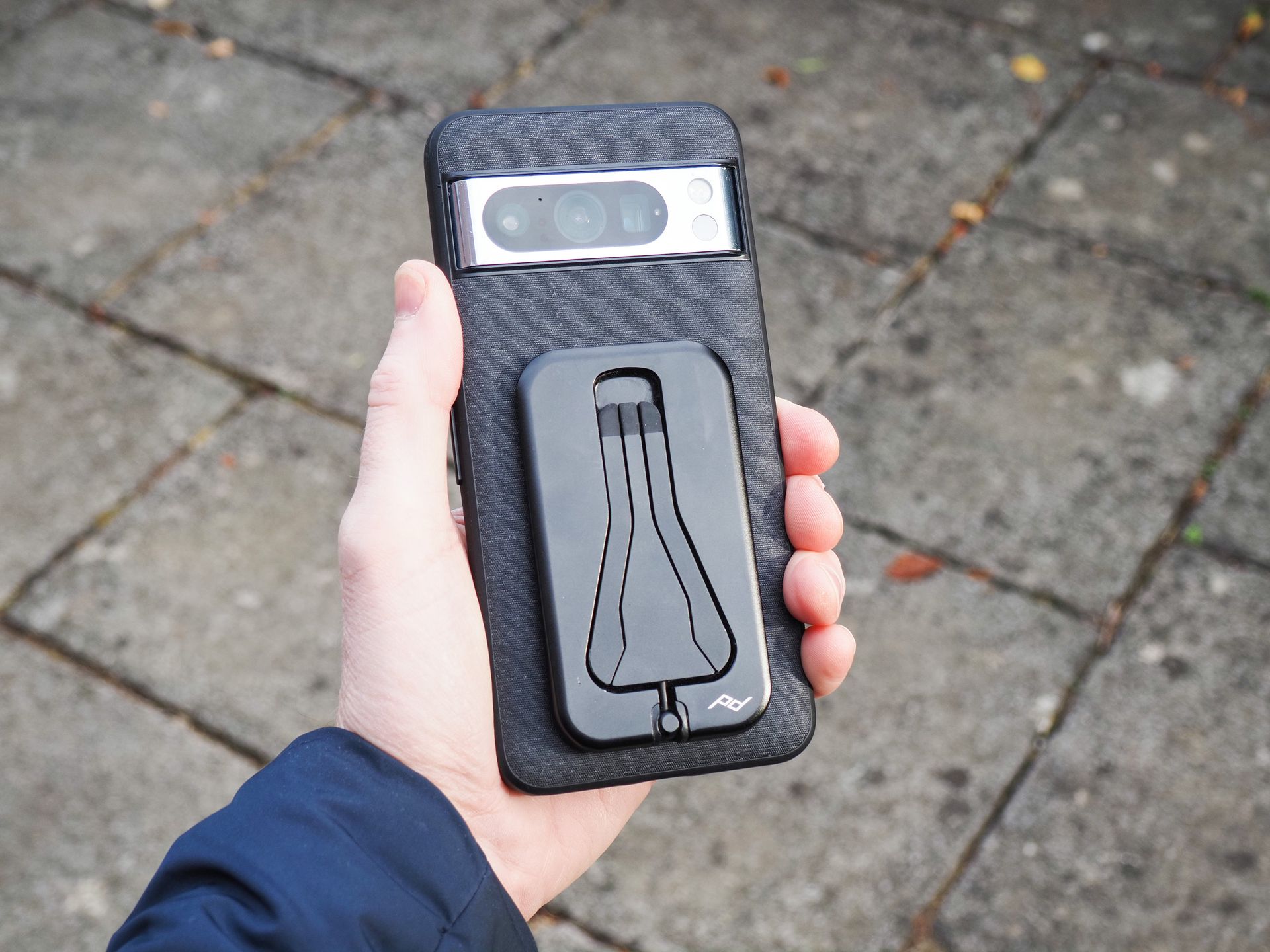 Peak Design Mobile Tripod folded away attached to a Pixel phone with Peak Design's dedicated case, in user's hand