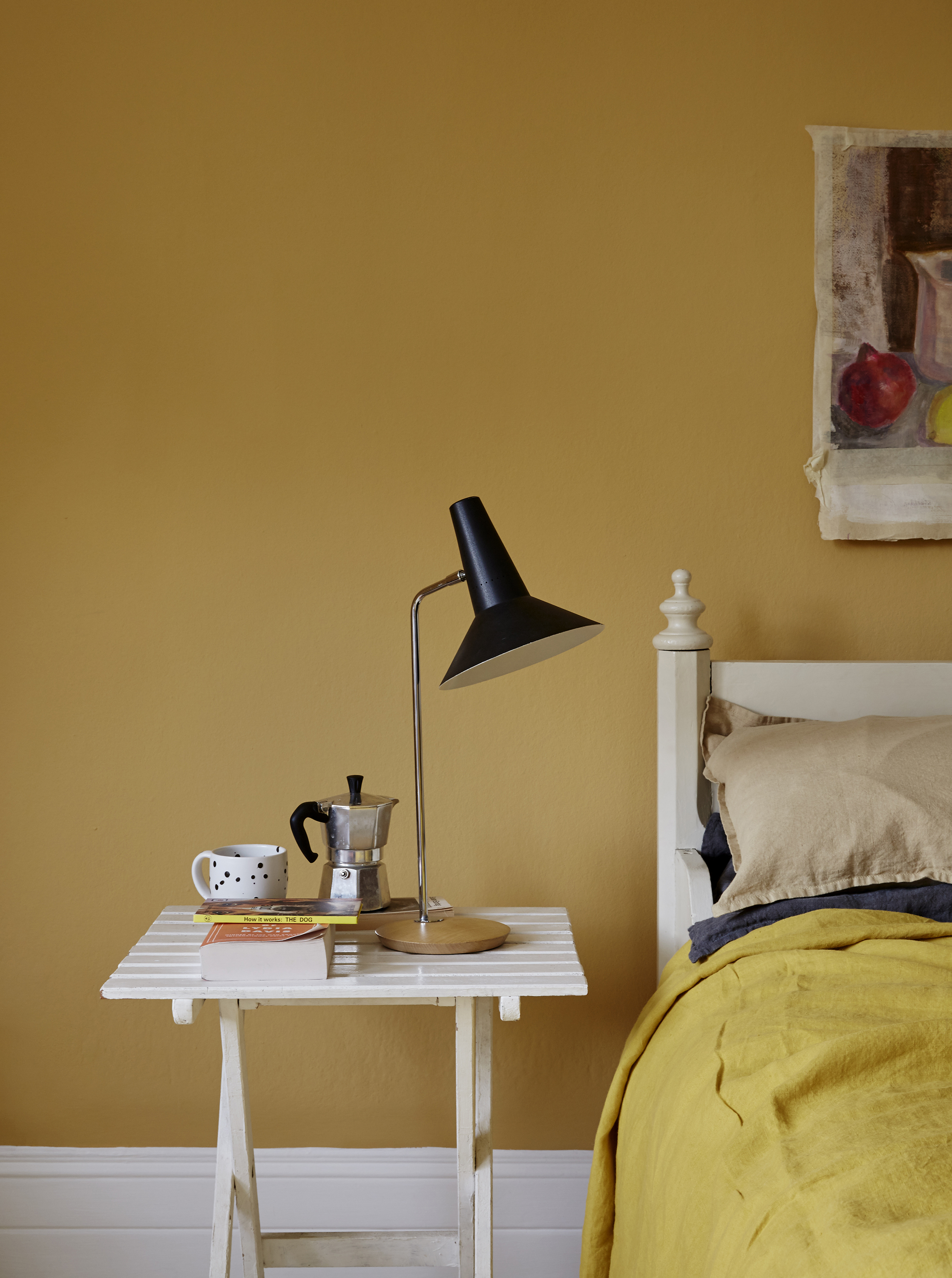 A Mustard yellow bedroom using paint shade 'Humpty Dumpty' by Earthborn on walls