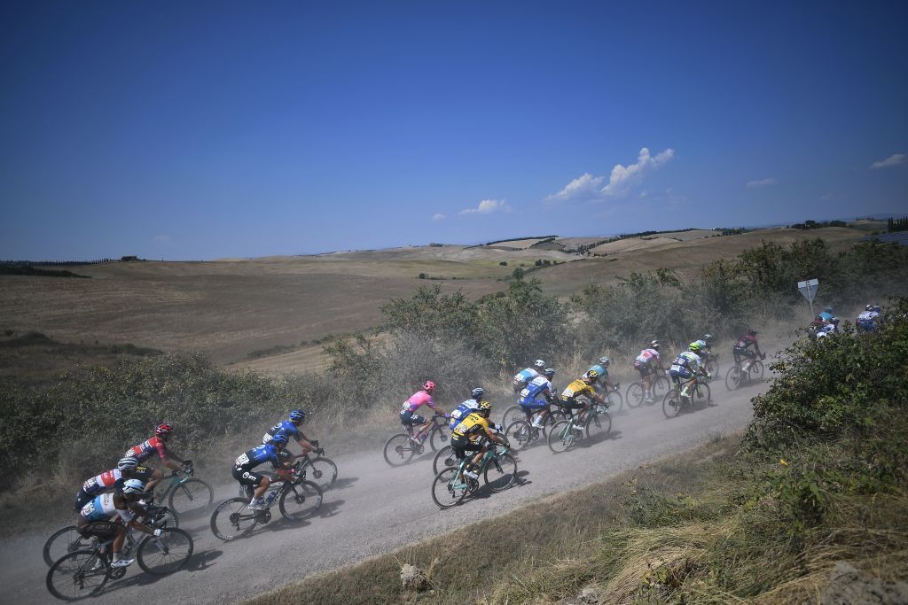 The pack of rider pedal through a dusty gravel road near Buonconverto during the oneday classic cycling race Strade Bianche White Roads on August 1 2020 around Siena Tuscany Photo by Marco Bertorello AFP Photo by MARCO BERTORELLOAFP via Getty Images